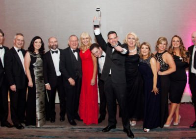 Roger Murray holding Law Firm of the Year award with staff at the awards